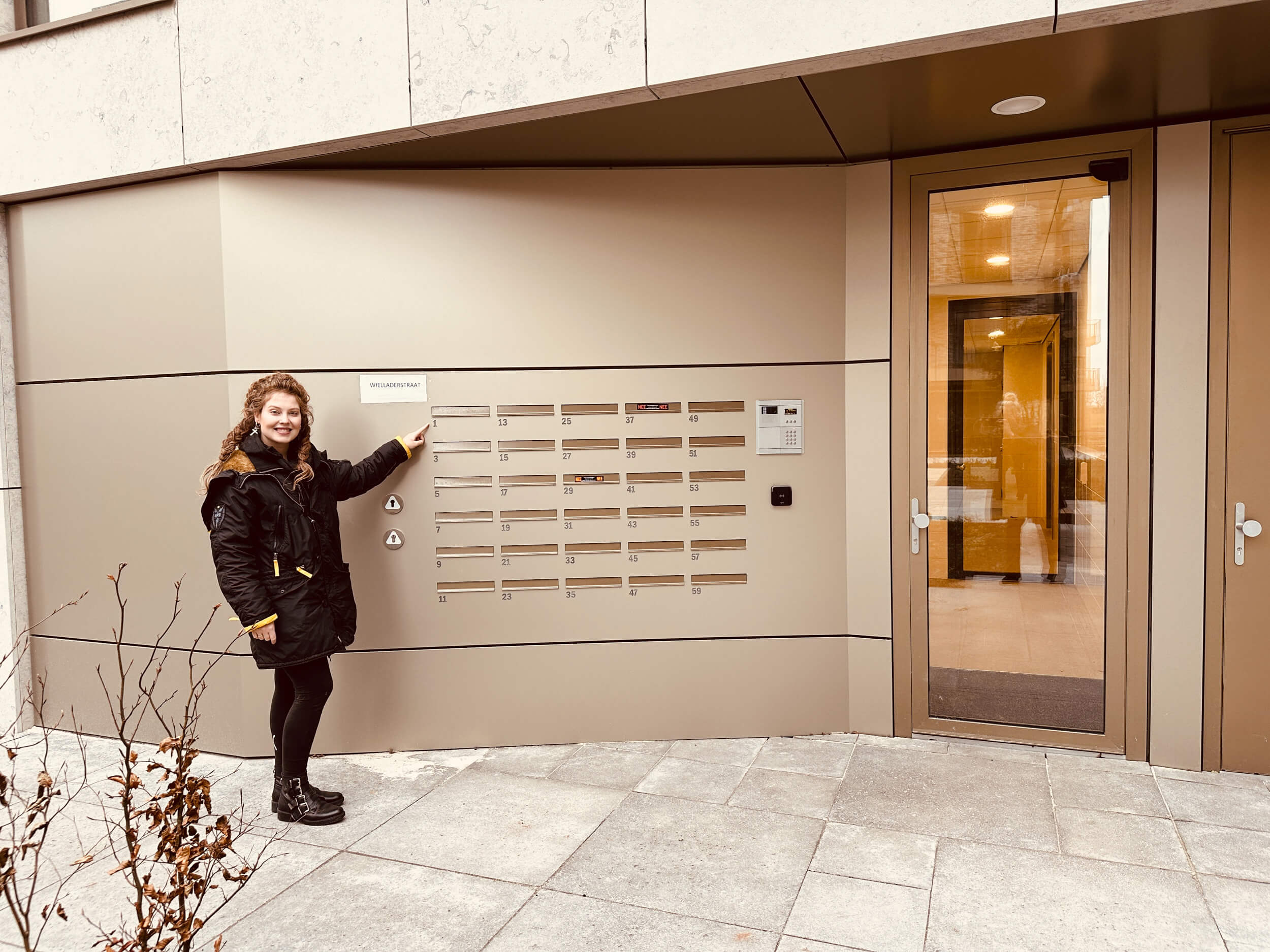 Sarina trots bij de entree van haar nieuwe huis