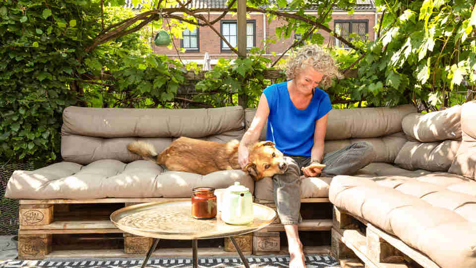 Vrouw met hond op tuinbank